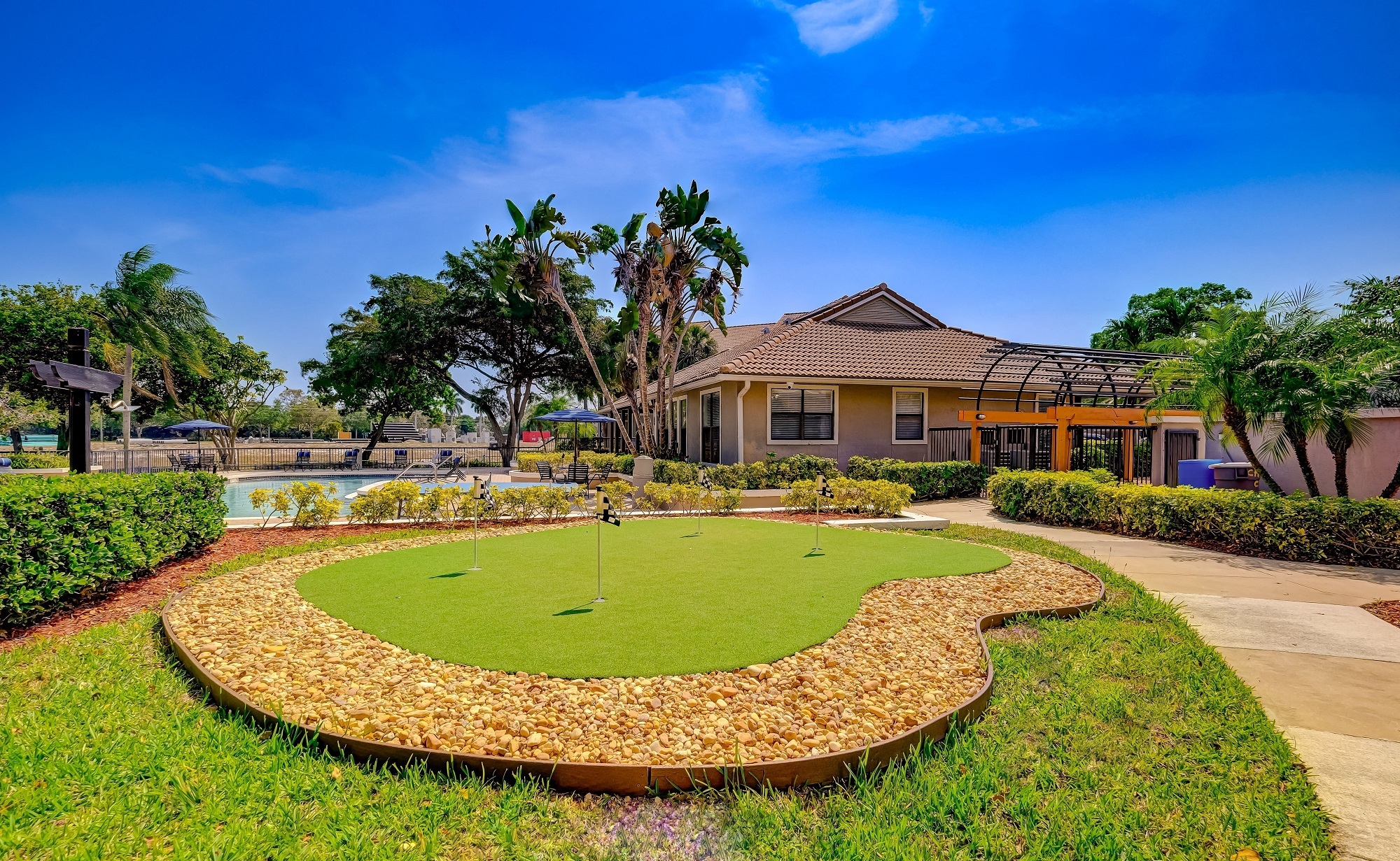 a home with a putting green in front of a house